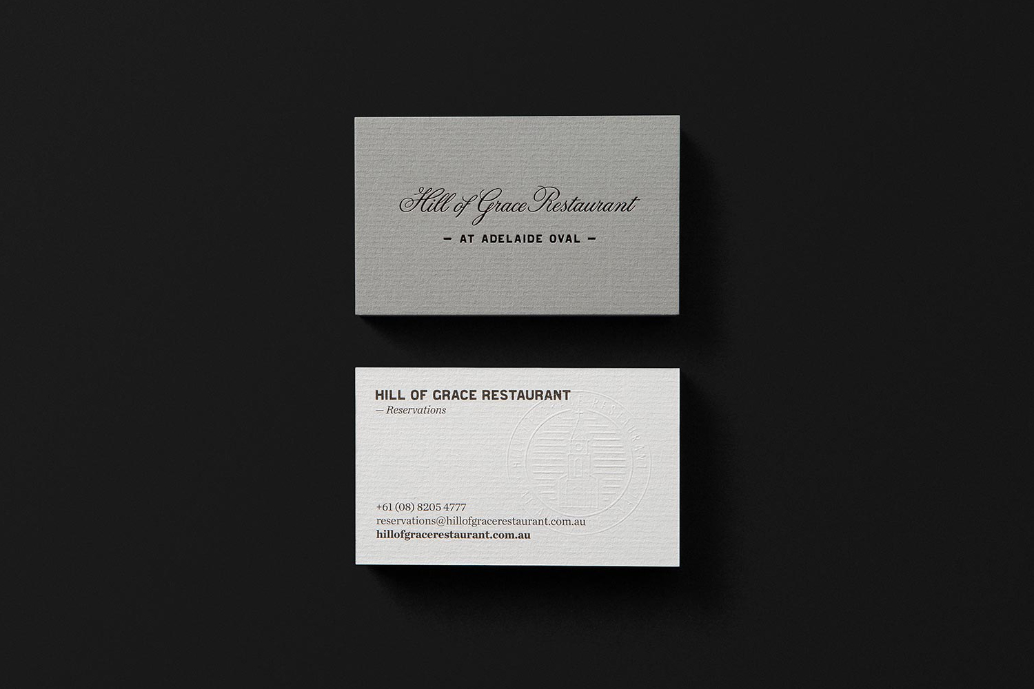Business cards with emboss, foil and laid paper detail designed by Band for restaurant Hill Of Grace at Adelaide Oval