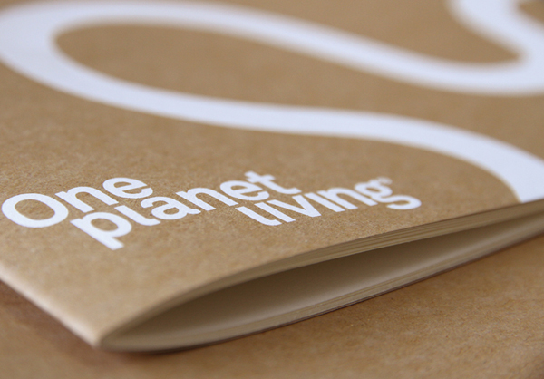 Printed collateral featuring white ink on unbleached substrate for One Planet Living designed by Demian Conrad