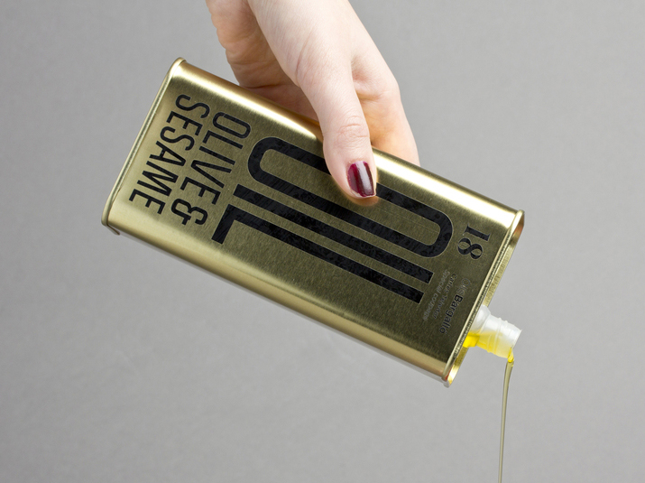 Packaging with condensed sans-serif typography and gold tin for Olive & Sesame Oil designed by Lo Siento