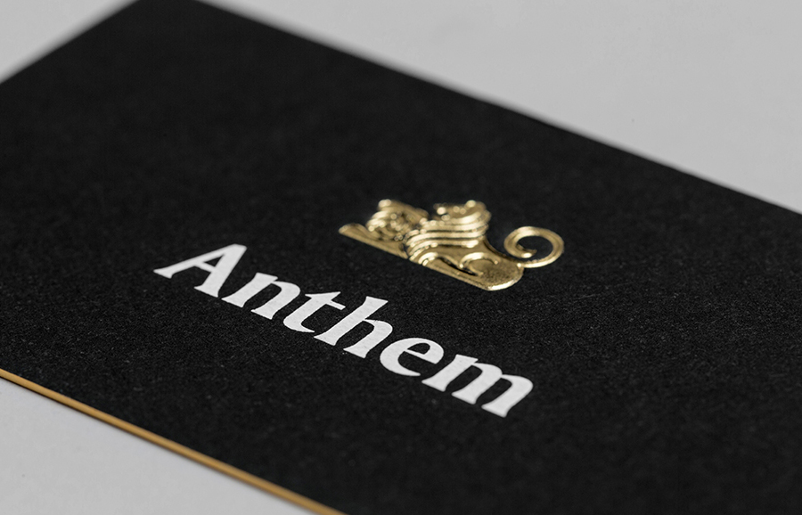 Logo and business card with embossed gold foil detail by Anagrama for football scout and transfer business Anthem