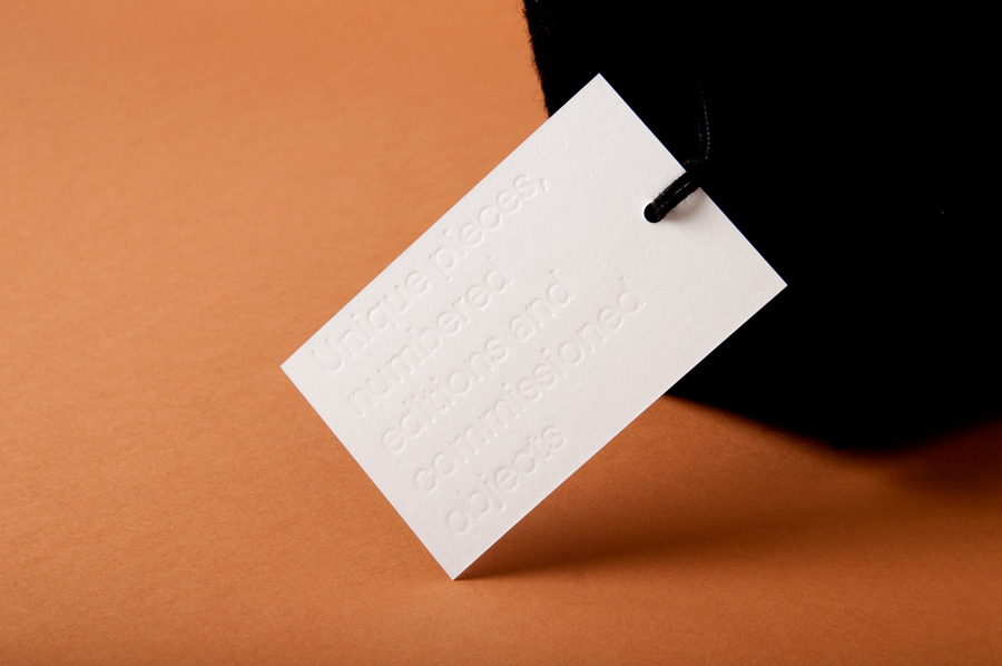 Tag with blind embossed sans-serif typography designed by P.A.R for Numbered by Martín Azúa