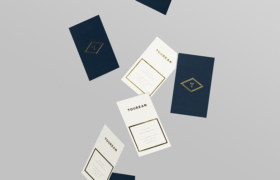 Logotype and business card with gold foil detail for British multinational venture capital firm Tourean designed by Anagrama 