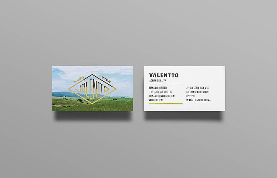 Logo and business card with gold foil and photographic landscape detail designed by Anagrama for olive oil brand Valentto