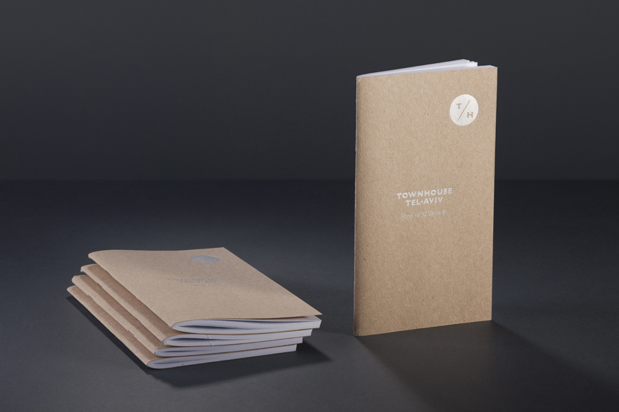 Logo and notebook with white ink detail across an unbleached paper for Tel Aviv hotel Townhouse designed by Koniak