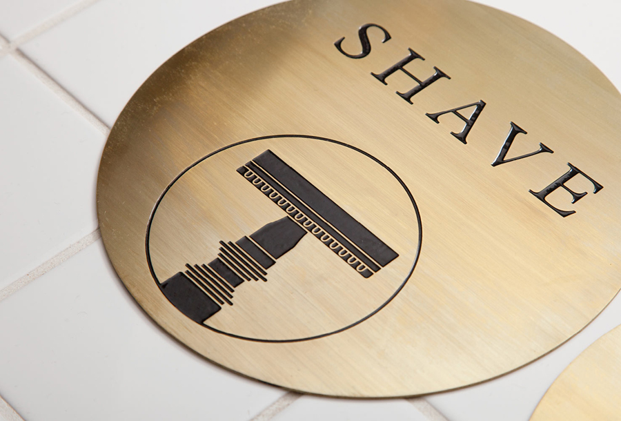 Acid-etched brass signage by ThoughtAssembly for male grooming business Men's Biz