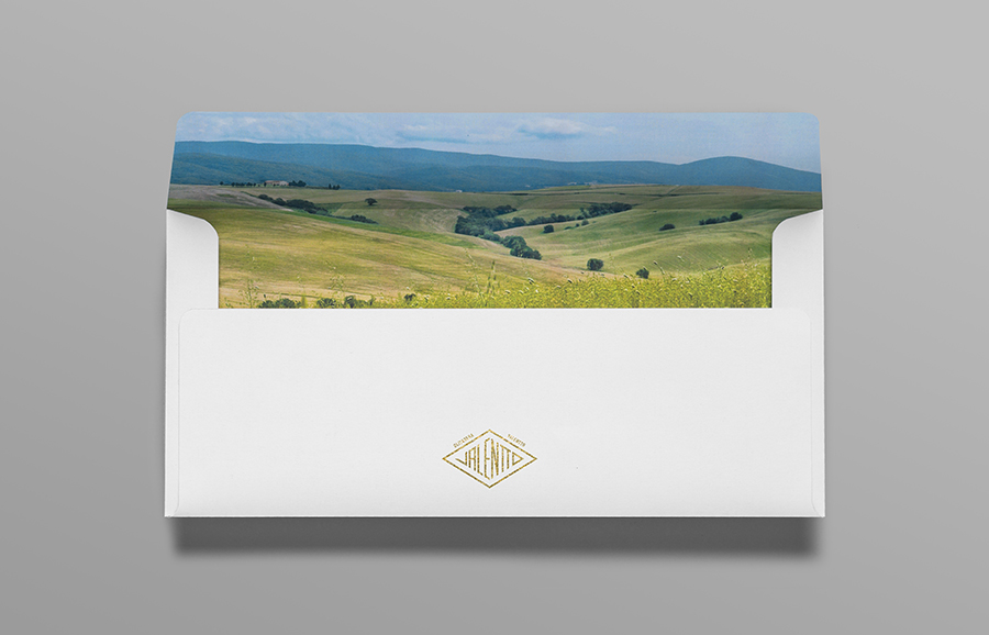Logo and envelope with gold foil and photographic landscape detail designed by Anagrama for olive oil brand Valentto
