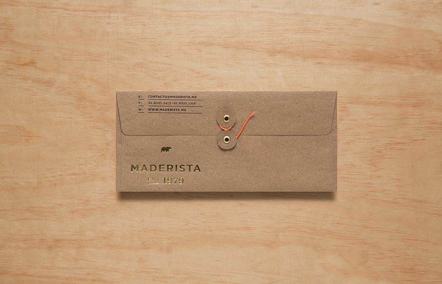 Logo and envelope with gold foil finish across an unbleached substrate designed by Anagrama for San Pedro-based carpentry studio Maderista