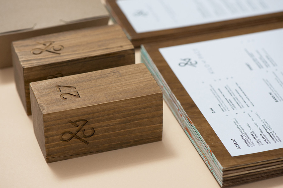 Logo, wood carved table numbers and wood veneer menus designed by Acre for co-branded retail partnership Pact