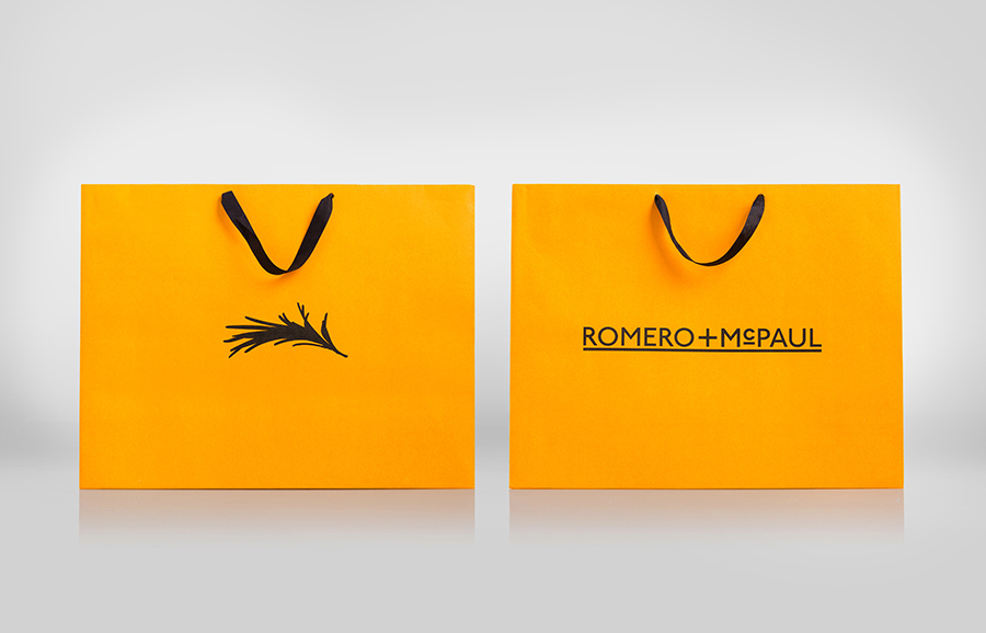 Logo and orange shopping bags created by Anagrama for luxury slipper brand Romero+McPaul