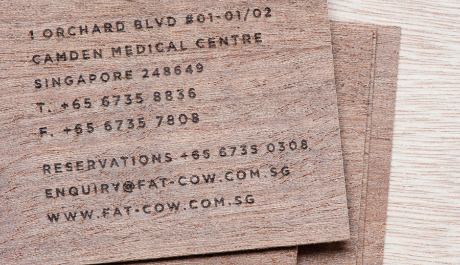 Logo and wood veneer business card with heat treated detail for specialist beef restaurant Fat Cow designed by Foreign Policy