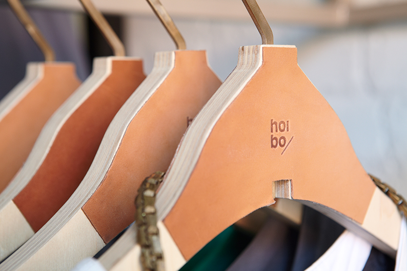 Logo and hanger with leather panel detail designed by Blok for luxury bag, clothing and accessories brand Hoi Bo