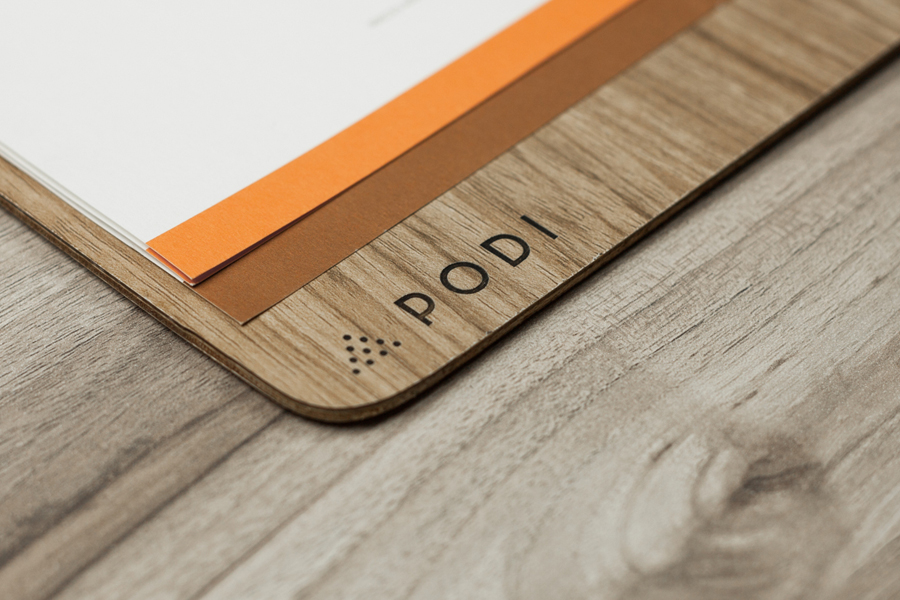 Logotype, menu with wood detail and coasters designed by Bravo Company for Singapore-based organic restaurant Podi