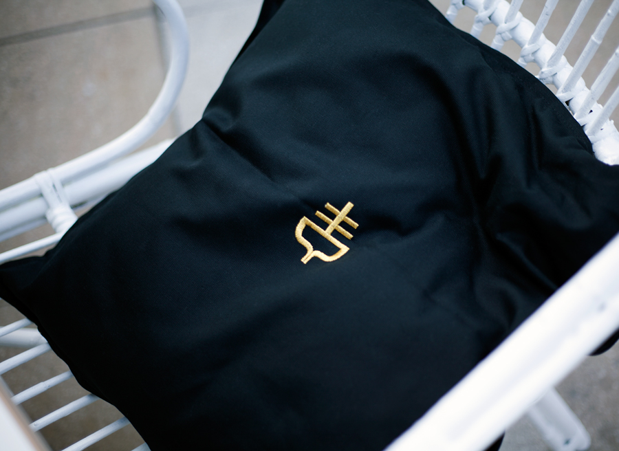 Cushion with gold stitched logo detail designed by Graphical House for The Empire Café