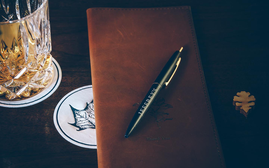 Coasters with and leather bound menu with stippled botanical illustration by FÖDA Studio for Jeffrey's