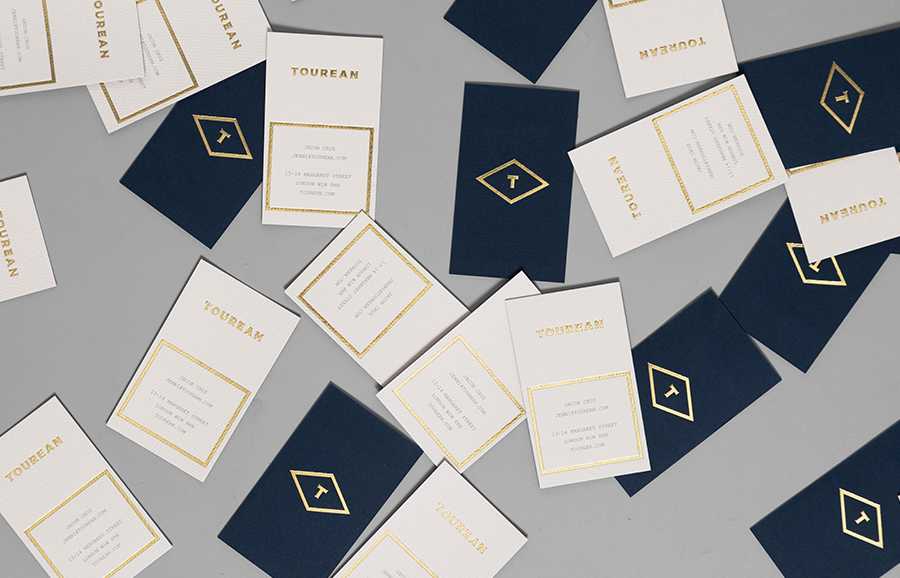 Logotype and business with card gold foil detail for British multinational venture capital firm Tourean designed by Anagrama 