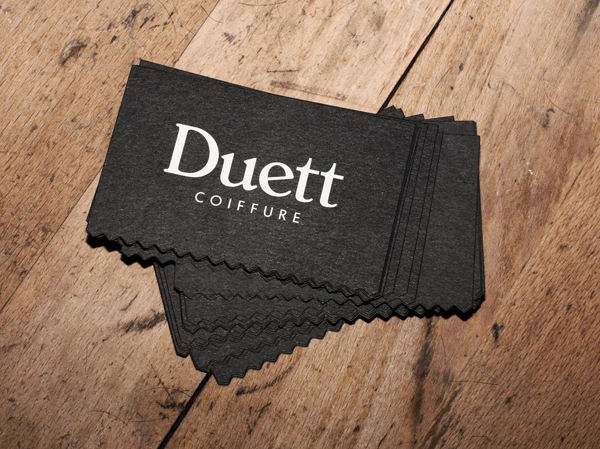 New logo and business card with white ink and die cut detail for Swiss hair salon Coiffure Duett designed by Bureau Collective