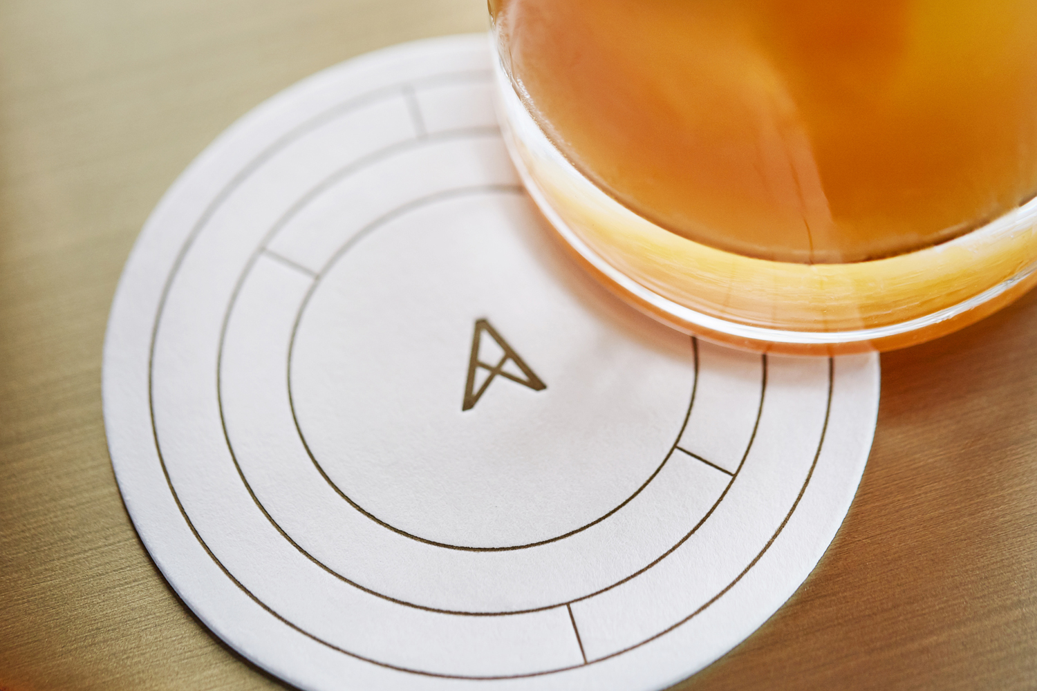 Brand identity and coaster with copper ink detail for Los Angeles restaurant Paley designed by Mucca, United States