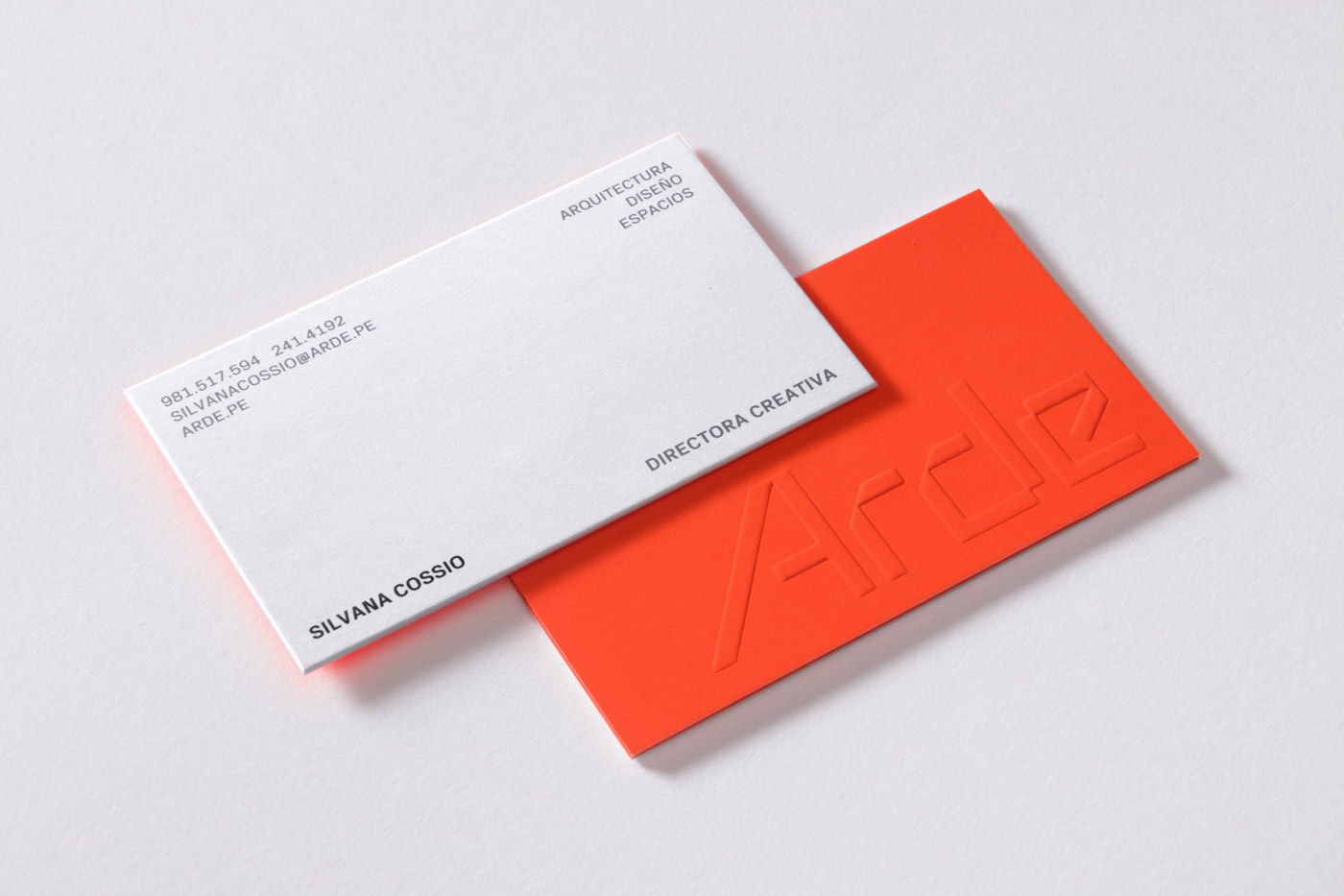 Business cards for Peruvian architecture business Arde by IS Creative Studio. These feature a bright fluorescent orange ink and blind emboss print print finish.
