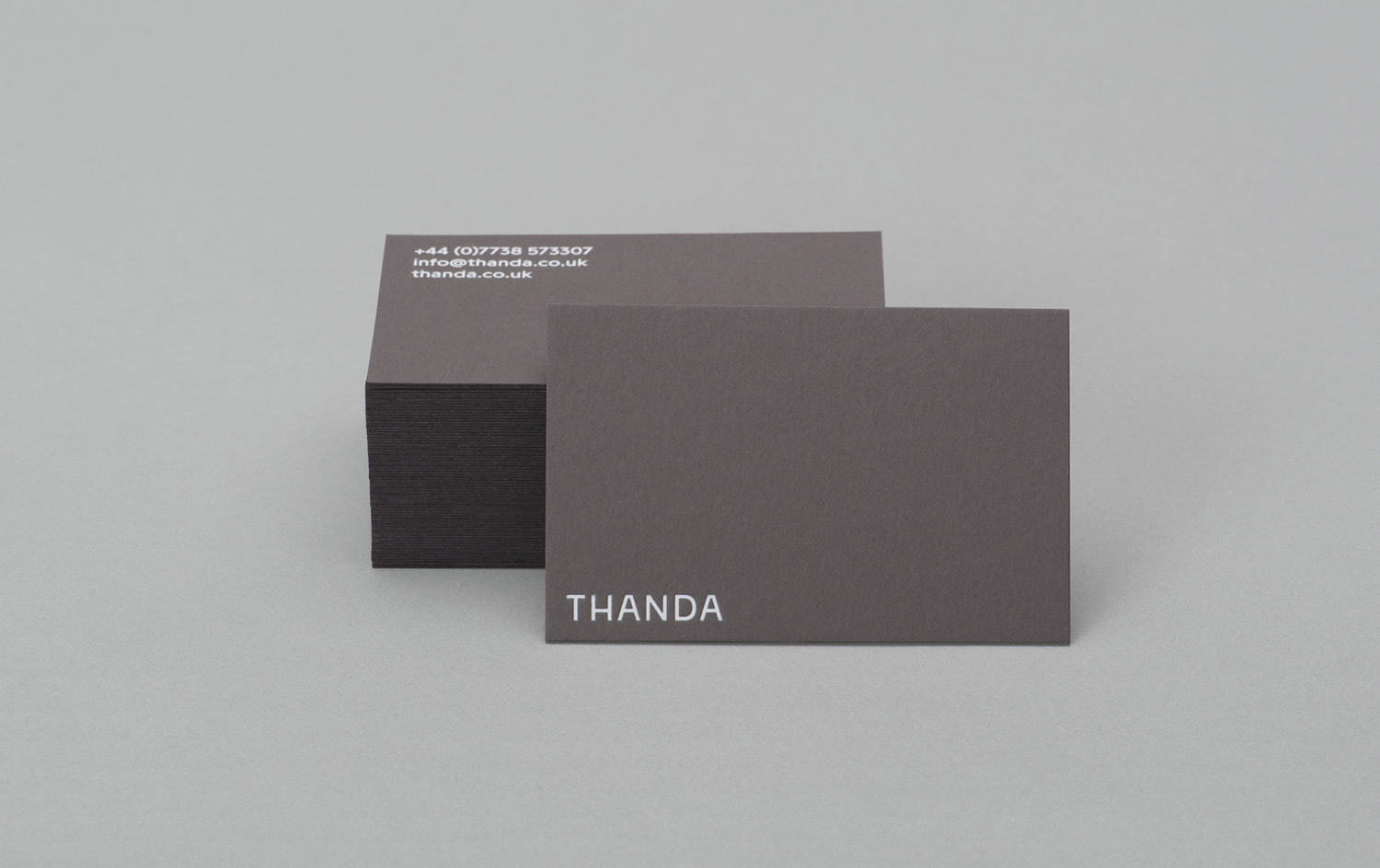 Brand identity and white foiled business cards by UK graphic design studio Karoshi for conscientious interior accessory business Thanda