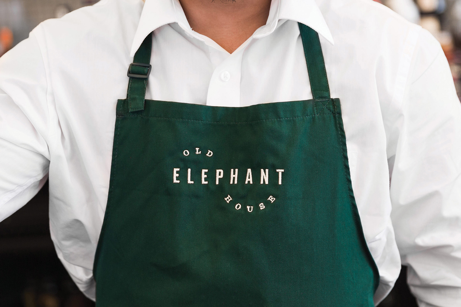 Logotype and embroidered apron design by Studio South for brasserie and courtyard bar Old Elephant House at Auckland Zoo