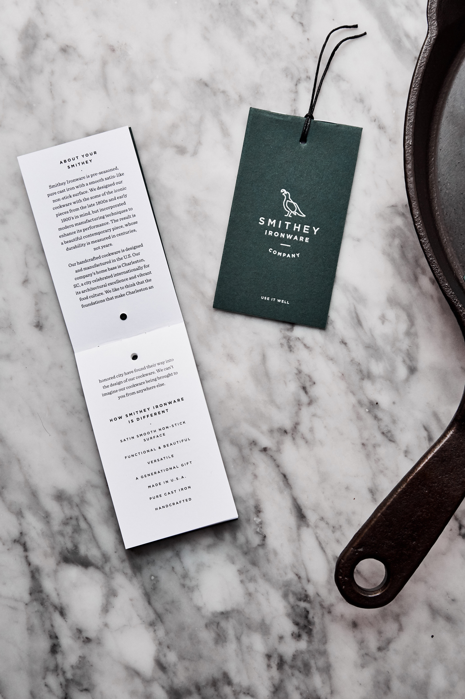 Brand identity and tags with green paper and white ink detail for Smithey Ironware Company by Charleston based Stitch, United States