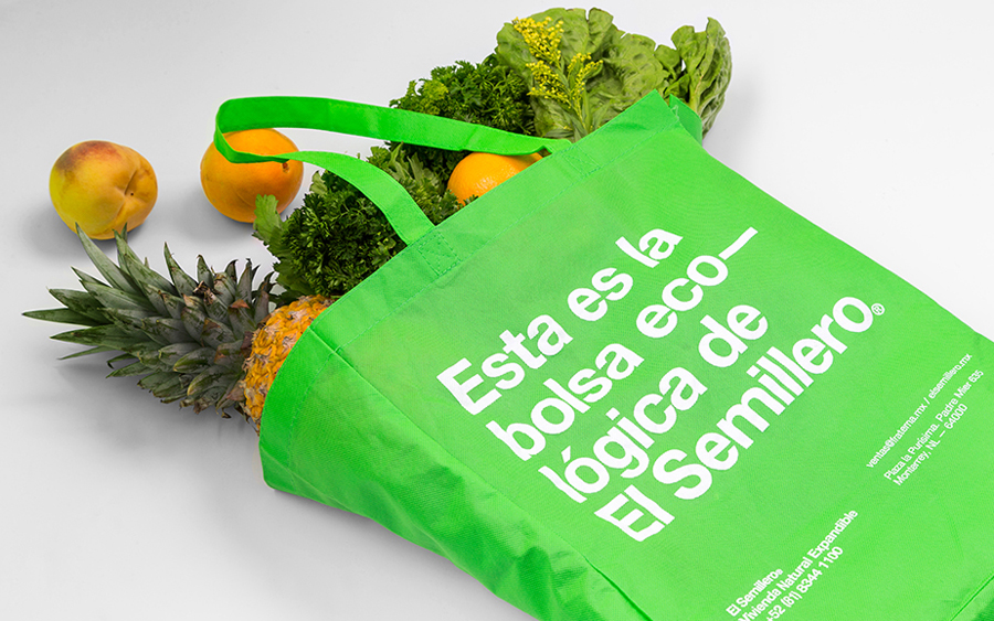 Green tote bag with white screen printed detail designed by Anagrama for residential property development El Semillero