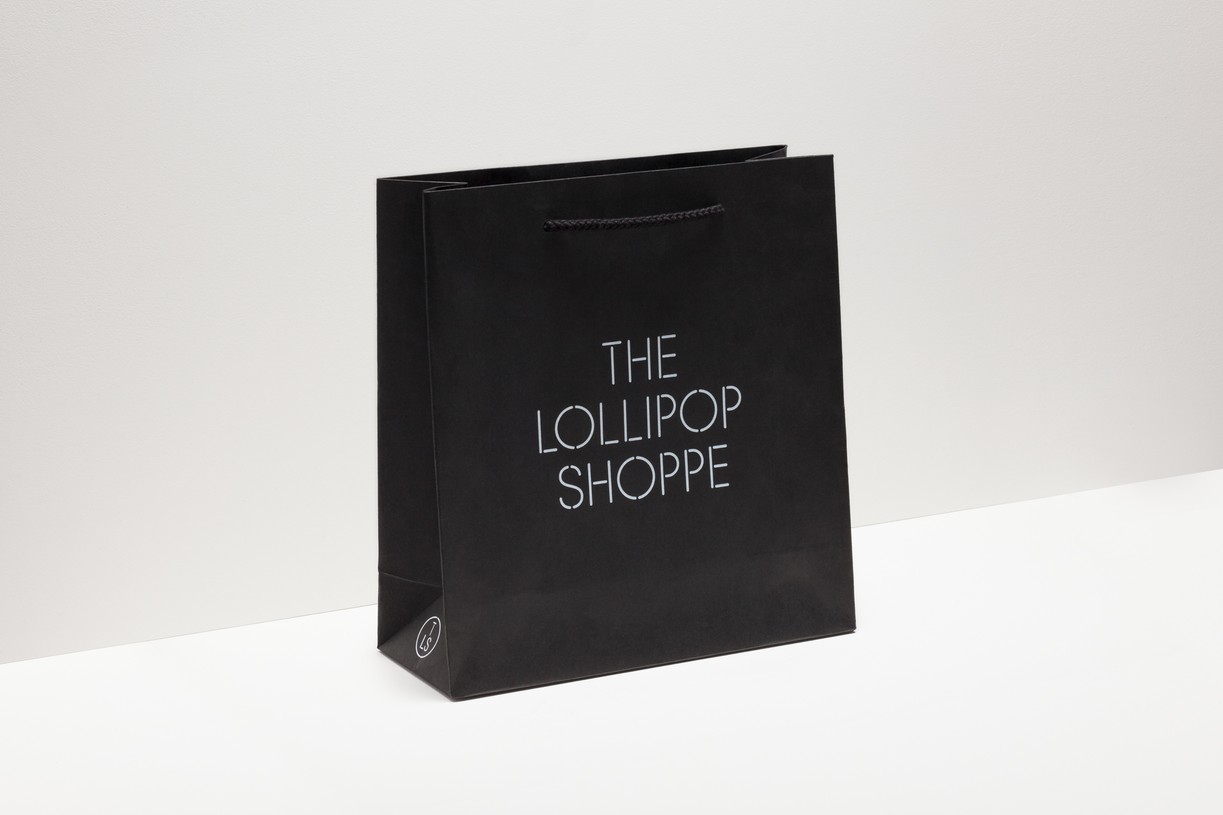 Logo and bag with white foil detail created by Studio Makgill for designer furniture and accessories retailer The Lollipop Shoppe