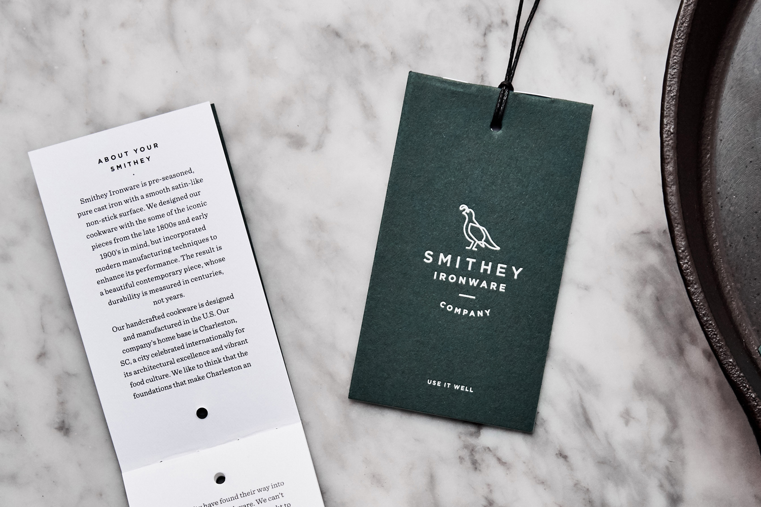 Brand identity and tags with green paper and white ink detail for Smithey Ironware Company by Charleston based Stitch, United States