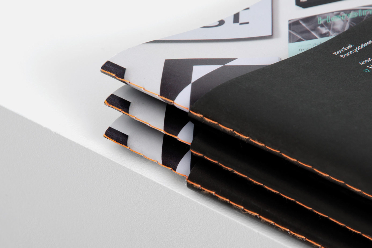 Graphic identity and brand book with orange stitch detail by dn&co. for commercial space Here East